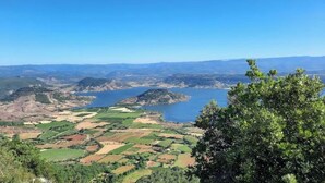 Vista panorâmica de uma paisagem costeira com campos e um corpo d'água.
