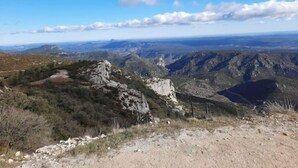 Paisagem montanhosa com terreno rochoso e vegetação escassa.