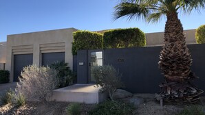 A modern house with a palm tree, a hedge, and a concrete pathway. - Colorful Artist’s Mansion w. pool and spa, pet friendly, all utilities included (Palm Springs)
