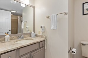 Een haardroger, handdoeken, zeep, toiletpapier