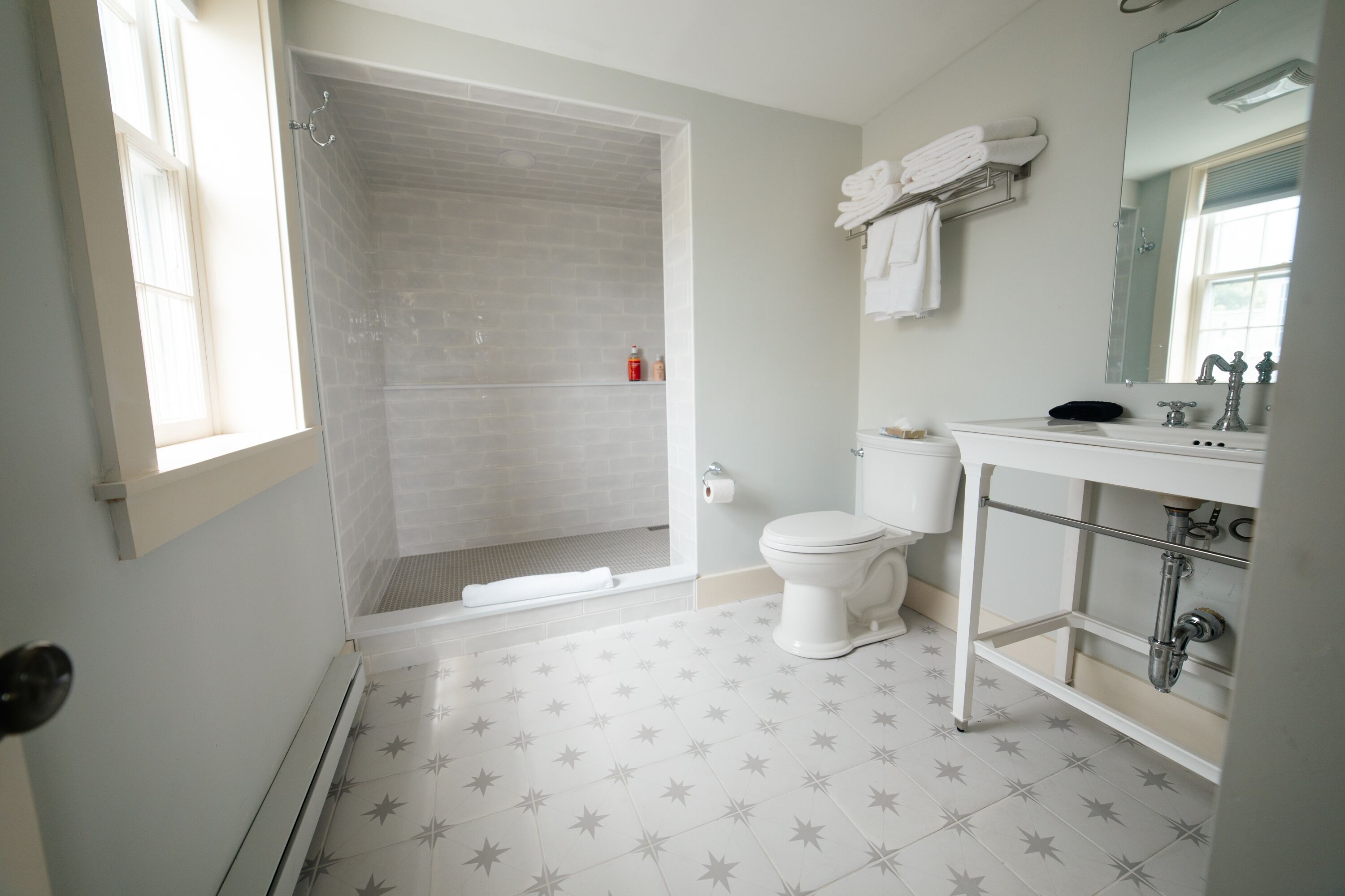 A bathroom with a shower, toilet, and sink.