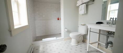 A bathroom with a shower, toilet, and sink.
