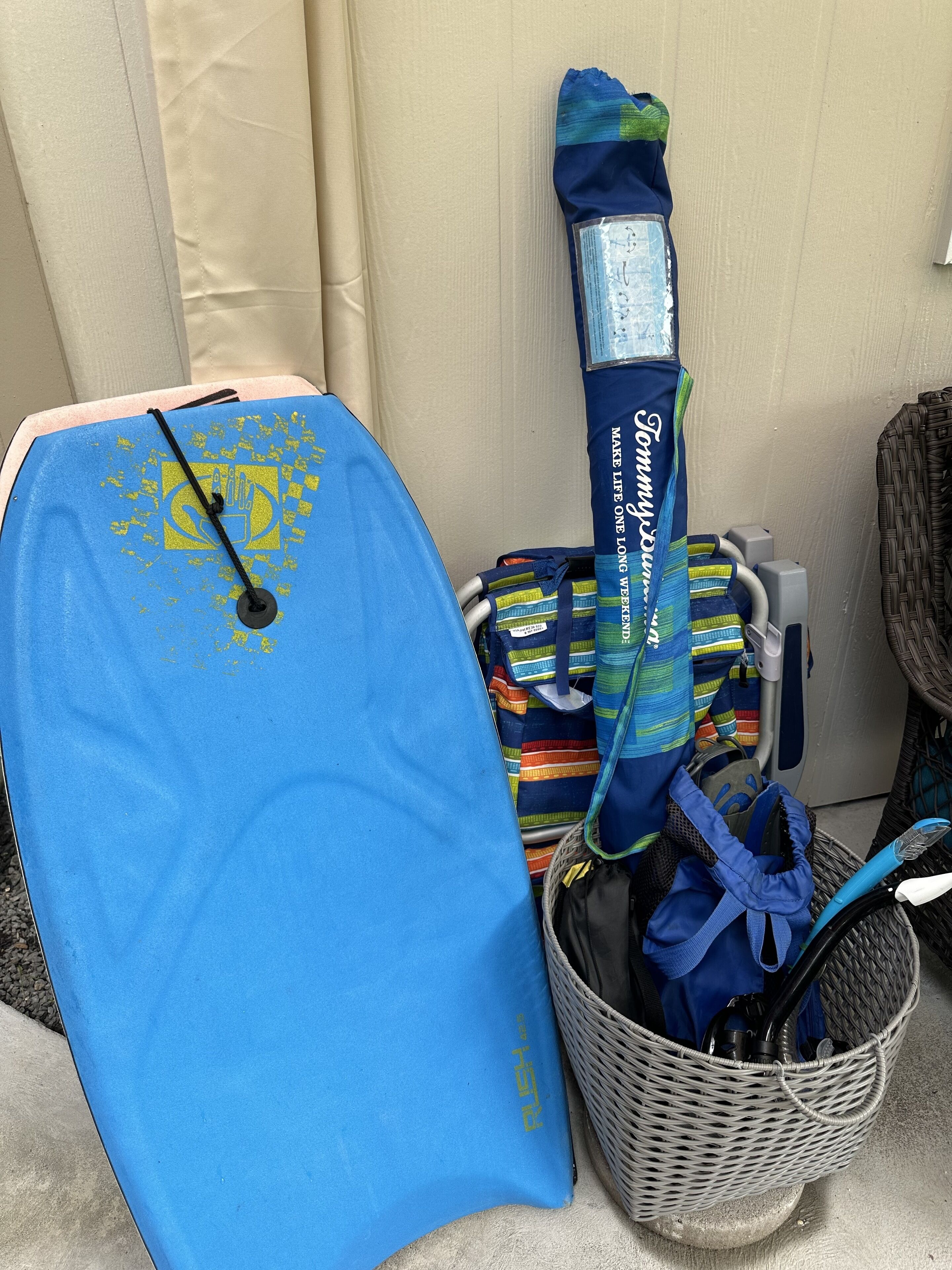 A blue mat with yellow symbols, a striped bag, and a wicker basket with a blue item.