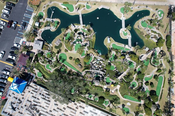 Vue aérienne d’un parc aménagé, avec des allées, des éléments d’eau et de la végétation.