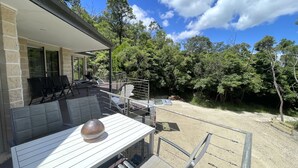 A patio area with outdoor seating and a view of a forested area. - Grand Retreat in Mount Eliza (Mount Eliza)