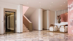Ein modernes Interieur mit Marmorboden, einer Treppe und einer Rezeption.