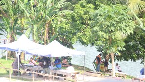 A lakeside area with several white tents and picnic tables. - Sunshine Inn (Luganville)