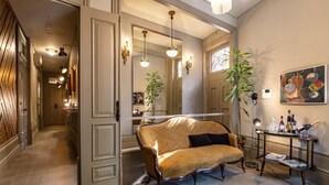 Een ruime woonkamer met een grote bank, een salontafel en een aan de muur bevestigde televisie.