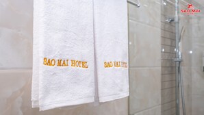 Dos toallas blancas colgadas en una pared con el texto "SAO MAI HOTEL" en letras doradas.