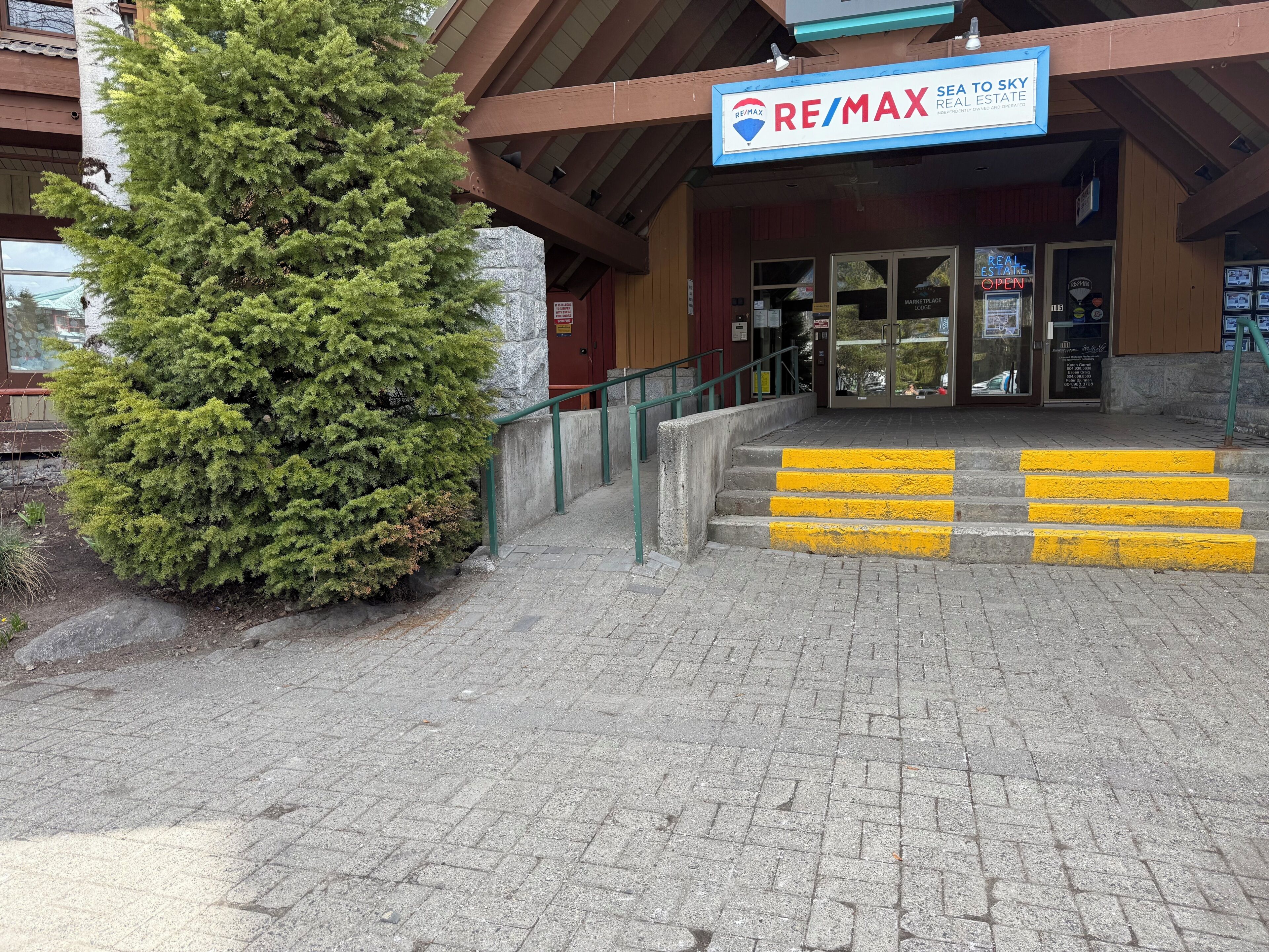 Un edificio comercial con un letrero de la agencia de bienes raíces RE/MAX.