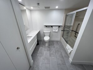 A modern bathroom with a toilet, sink, and glass shower enclosure.