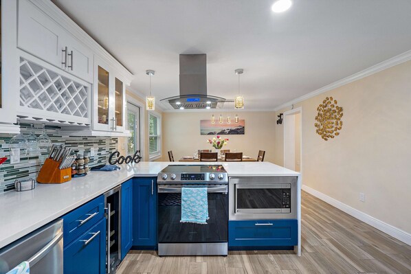 Enjoy cooking in the well-lit kitchen with a central island, oven, and stovetop.