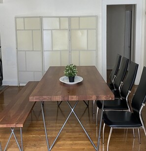 Un salón de conferencias con una mesa de madera, sillas negras y una planta en maceta.