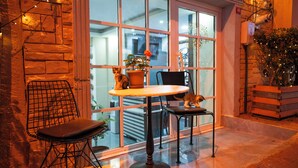 A cozy interior with a table and chairs, a potted plant, and a window with reflections. - Mila Suites Taksim (Istanbul)