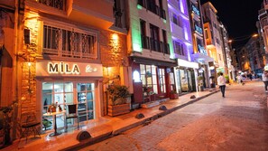 A street with a building labeled 'MILA' with a glass storefront and outdoor seating. - Mila Suites Taksim (Istanbul)