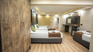 A hotel room with two beds, a wardrobe, a television, and a desk. - Mila Suites Taksim (Istanbul)