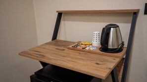 A small wooden table with a kettle, a tray of snacks, and a stack of star-patterned cups. - Mila Suites Taksim (Istanbul)