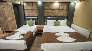 A hotel room with two beds, wooden headboards, a large mirror, and a radiator. - Mila Suites Taksim (Istanbul)