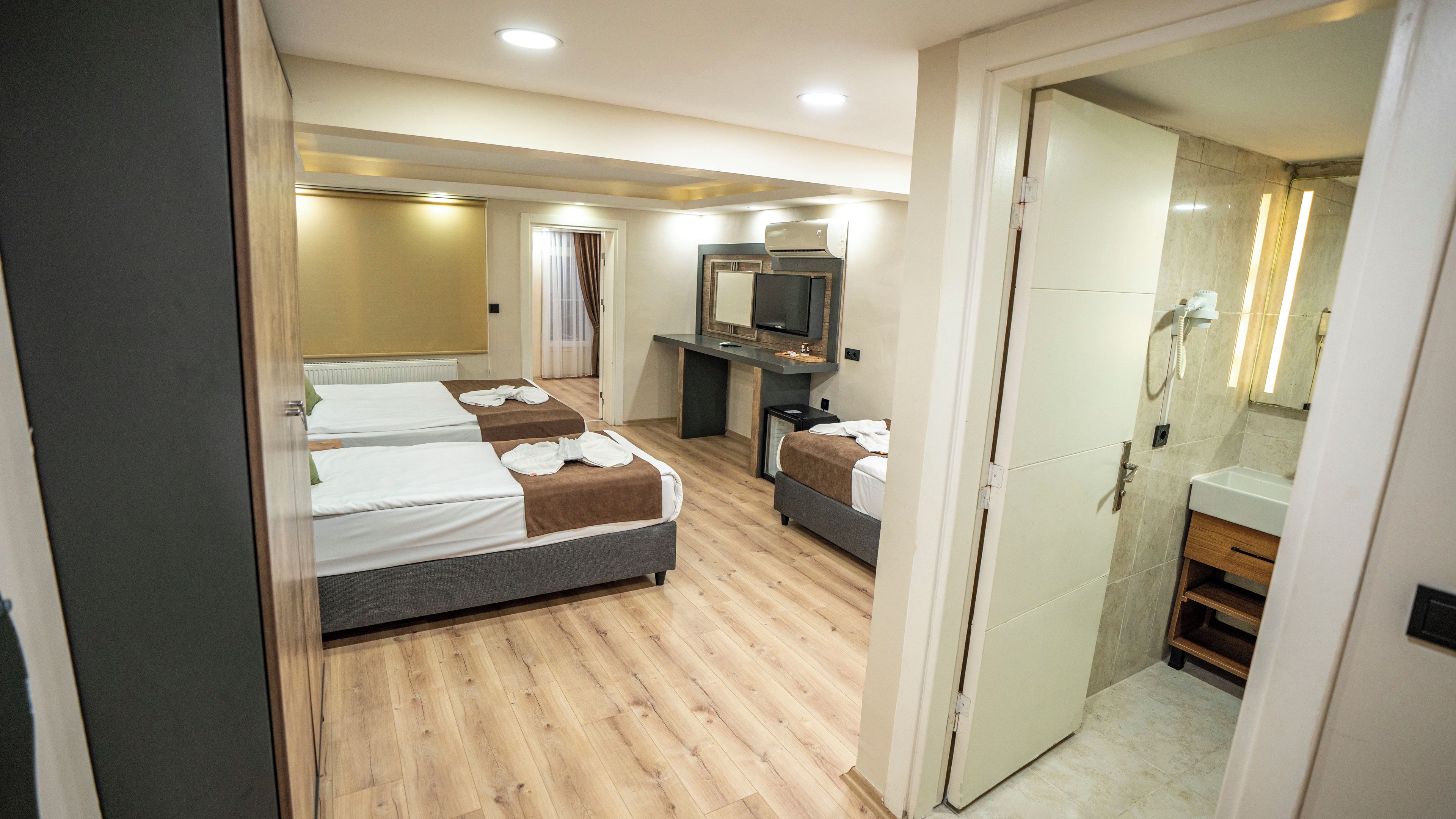Une chambre d’hôtel avec deux lits, un bureau, une télévision et une salle de bain.