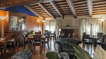 A spacious dining area with wooden furniture and a high ceiling with exposed beams.