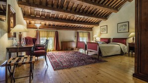 Quarto com teto de madeira, uma cama, uma escrivaninha e uma cadeira.