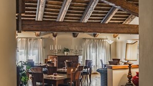 Un'accogliente sala da pranzo con travi in legno, un tavolo rotondo e sedie.