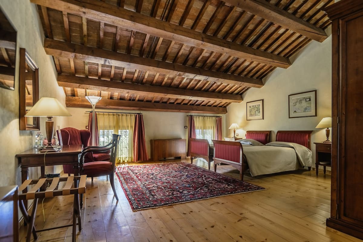 Ein Zimmer mit Holzboden, einem Bett, einem Schreibtisch und einem Stuhl.