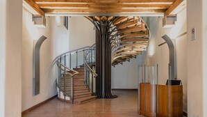 Una scala a chiocciola con gradini in legno e ringhiere in metallo, che conduce a un piano superiore.