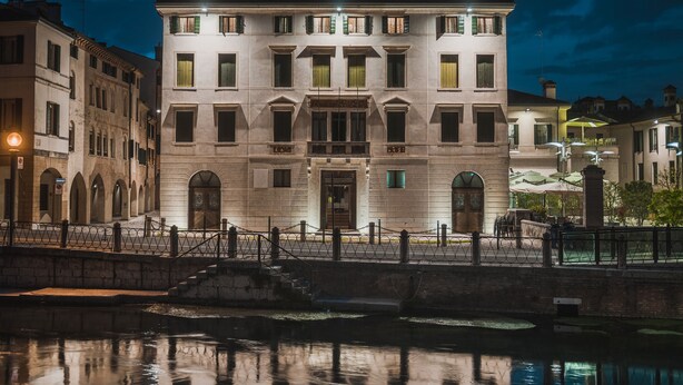 Un edificio storico con un ingresso centrale, finestre ad arco e un balcone.