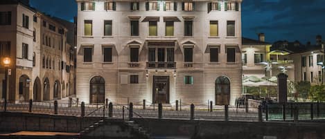Un edificio histórico de varios pisos, con una entrada central y un balcón con barandillas.