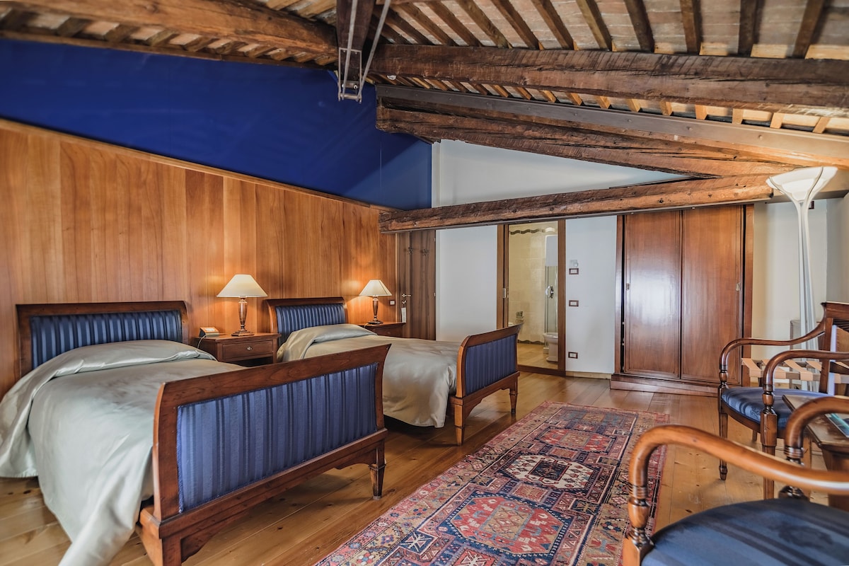 Une pièce avec deux lits en bois, un plafond bleu et une armoire en bois.