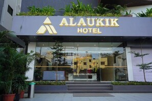 The exterior of the ALAUKIK HOTEL with a modern facade, large glass windows, and a visible entrance. - Alaukik Hotel (Rahata)