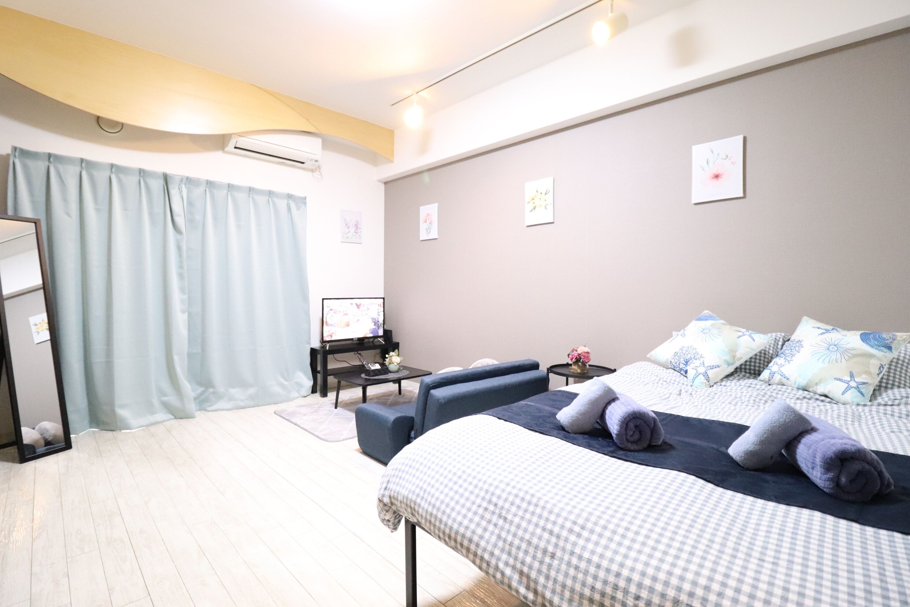 A hotel room with a bed, a desk, a chair, and a TV.