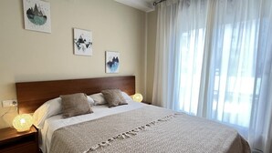 Una cama bien hecha con un edredón estampado, un cabecero de madera y dos lámparas de noche.