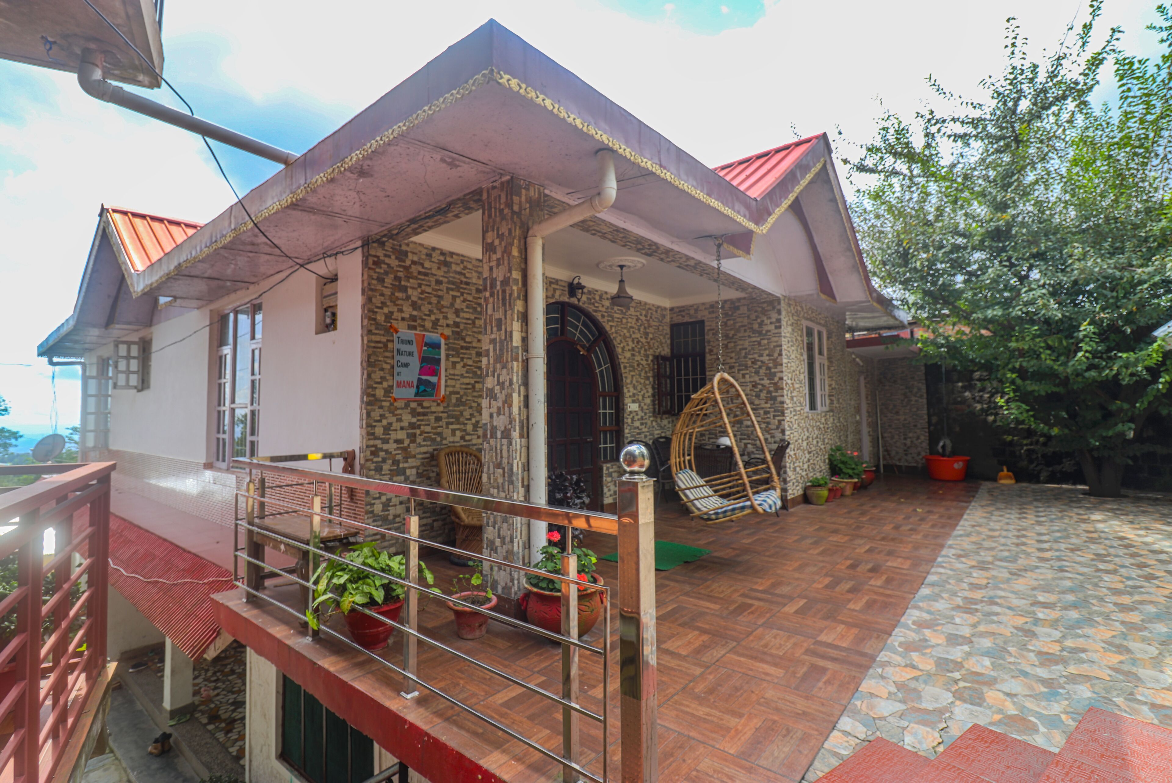 Una casa con balcón, una mecedora y plantas en macetas.