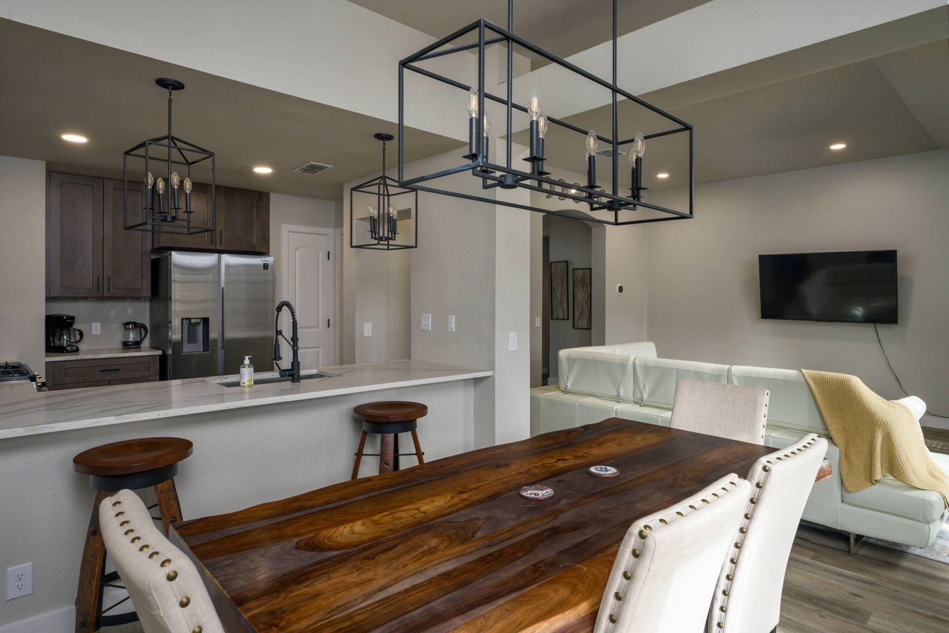 Open floor plan with large dining room table, sofa and big screen streaming TV