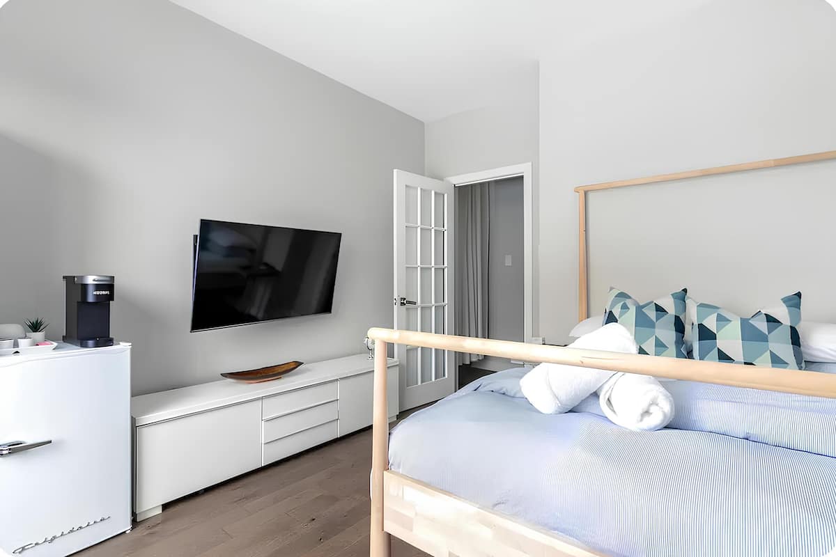 Une chambre moderne équipée d’un lit, d’une télévision, d’une machine à café et d’une armoire.