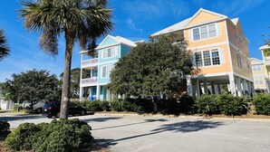 A two-story building with a balcony and a porch, surrounded by greenery and a clear blue sky. - Ocean Views New 4BR Steps from Beach (Myrtle Beach)
