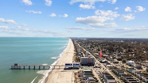 A coastal town with a beach, a pier, and residential buildings.