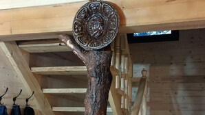 A rustic wooden staircase with a decorative metal plate at the top. - ART House Transylvania Sibiu (Avrig)