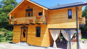 A wooden cabin with a balcony, a door, and a window. - ART House Transylvania Sibiu (Avrig)