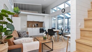Ein modernes Interieur mit Küche, Essbereich und Treppe.