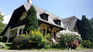 A traditional chalet-style house with a steeply pitched roof, wooden beams, and a balcony.