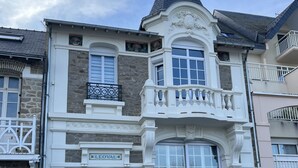 Een historisch gebouw met een stenen gevel, een opvallend balkon met balustrades en een klokkentoren.
