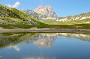 Un paysage de montagne avec un lac aux eaux limpides qui reflète le paysage environnant.