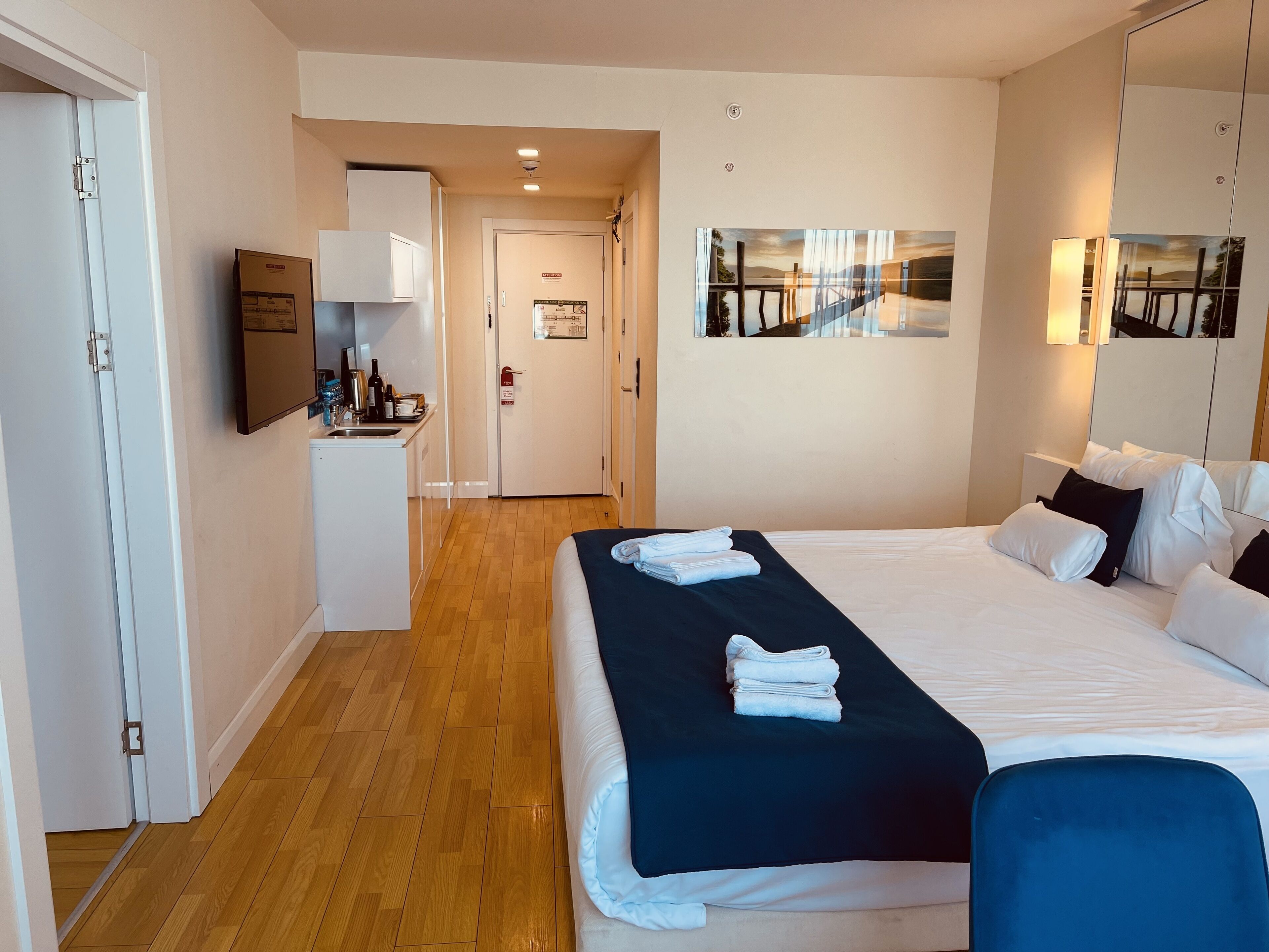 Ein Hotelzimmer mit Bett, Schreibtisch und einer Küchenzeile.