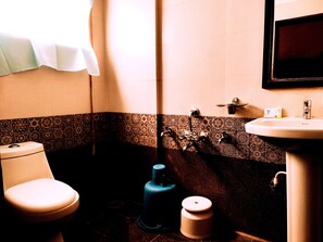 Een badkamer met toilet, wastafel en douche.