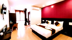 Una habitación de hotel con una cama grande, un escritorio y un televisor.