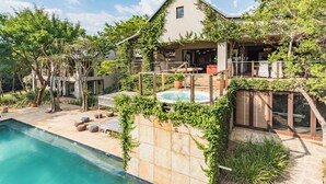 Una casa moderna con piscina, mobiliario de exterior y jacuzzi.