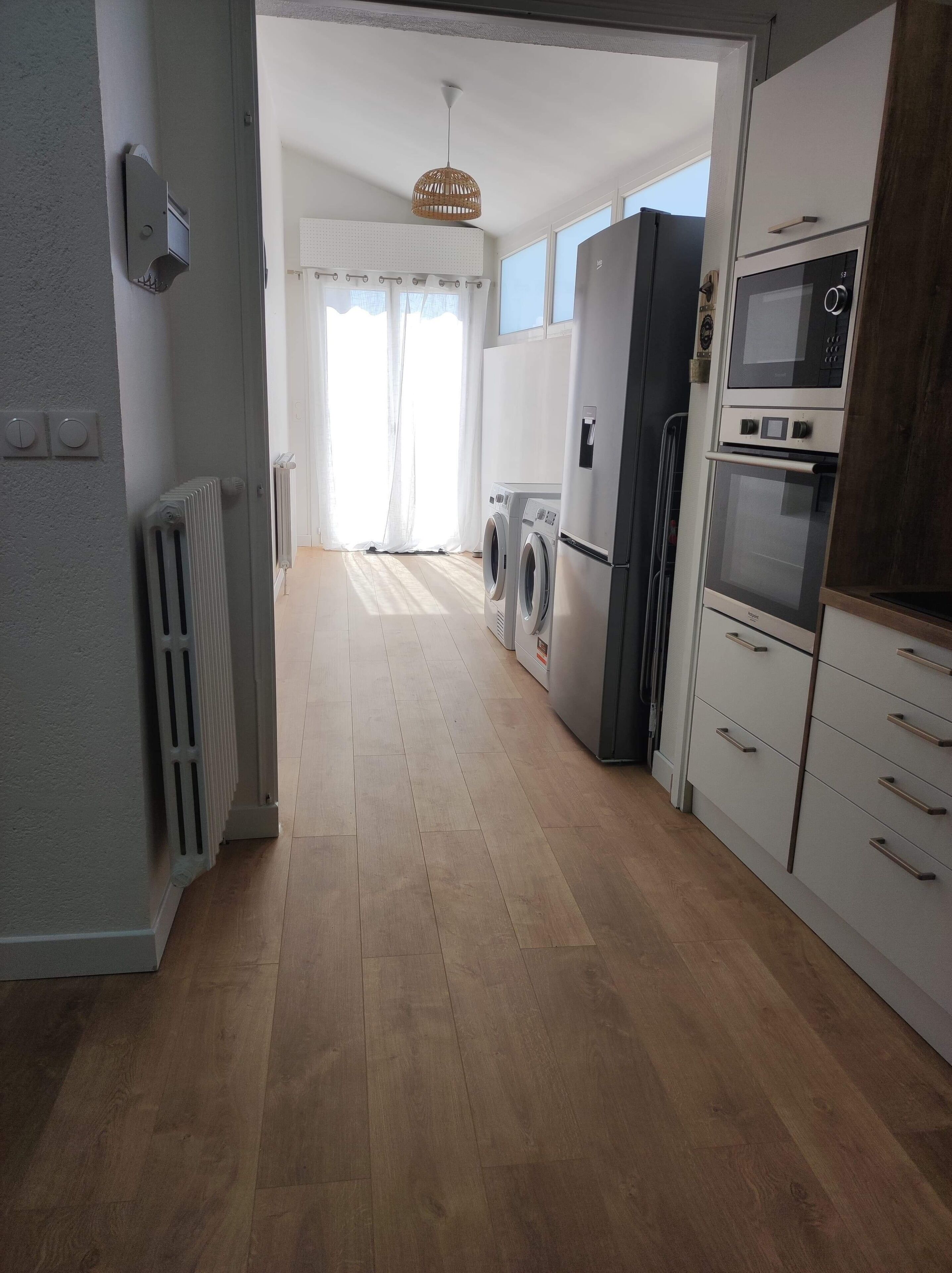 Eine moderne Küche mit Einbauofen, Mikrowelle und Waschmaschine.